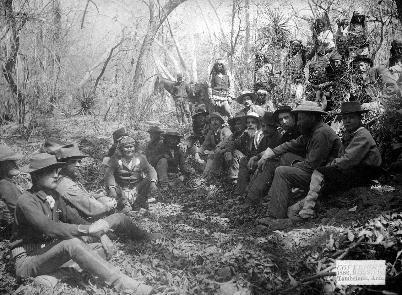 Geronimo sits with General Miles and officers at the surrender council