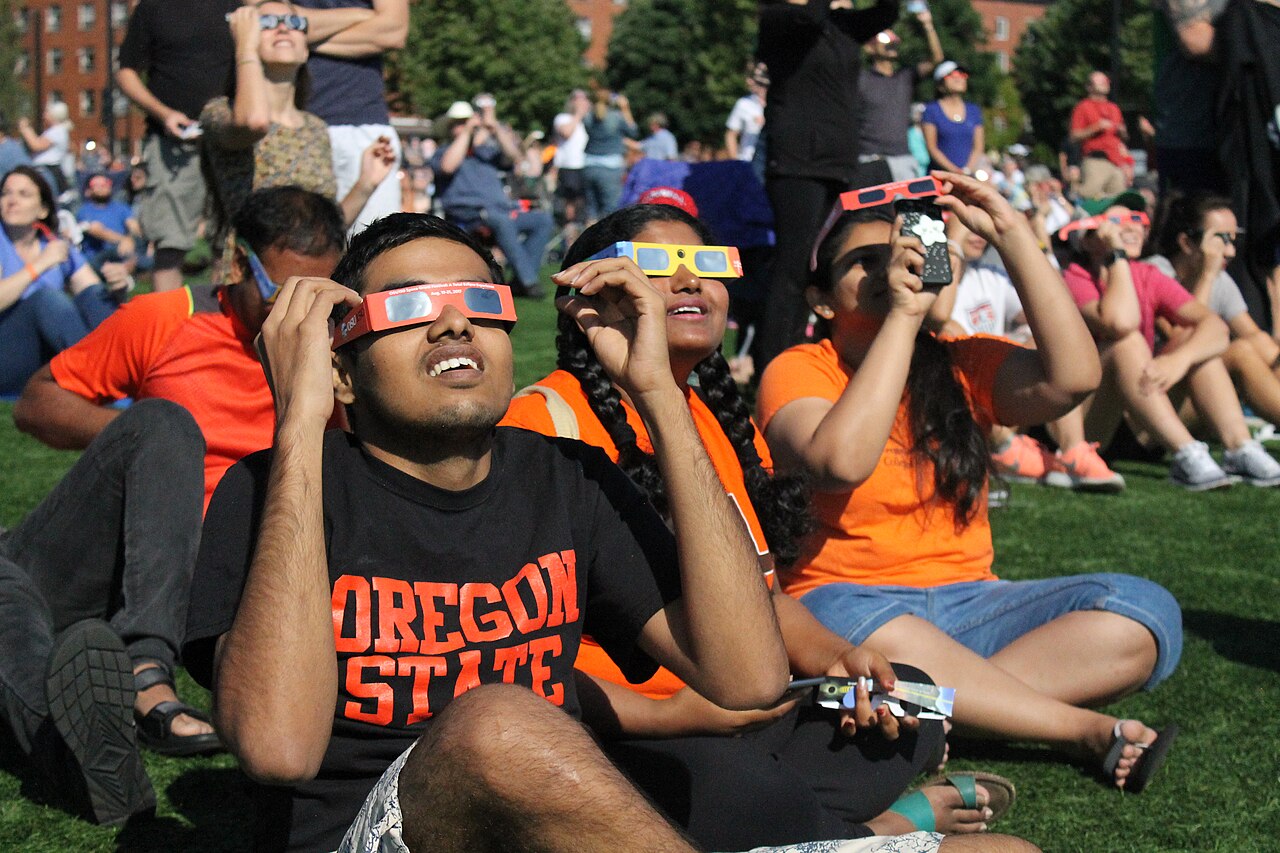 Crowds wear protective glasses to watch the solar eclipse