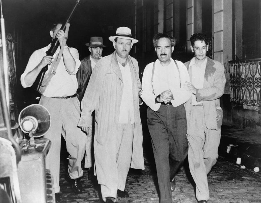 Police escort a captured nationalist from Blair House after the failed attempt