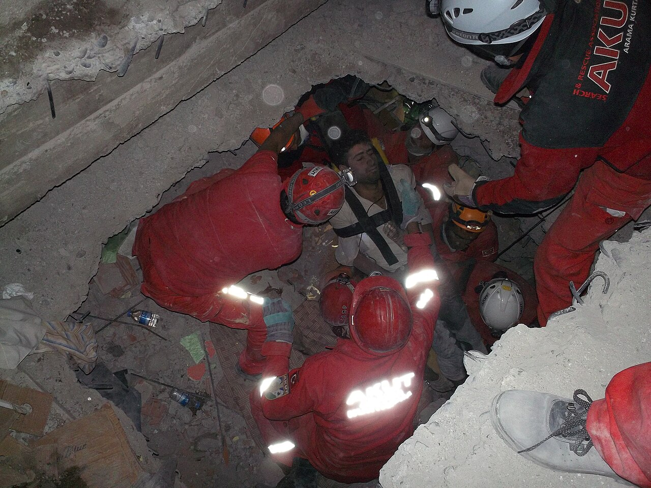 Rescue workers pull a survivor from the rubble of a collapsed building