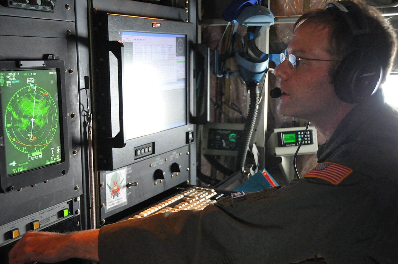 A United States Air Force crew member monitors weather data during a hurricane reconnaissance mission