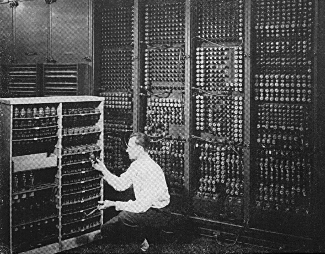 A technician works at an early computer mainframe