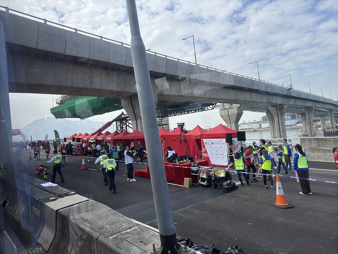 Officials gather at the bridge entrance as traffic prepares to cross