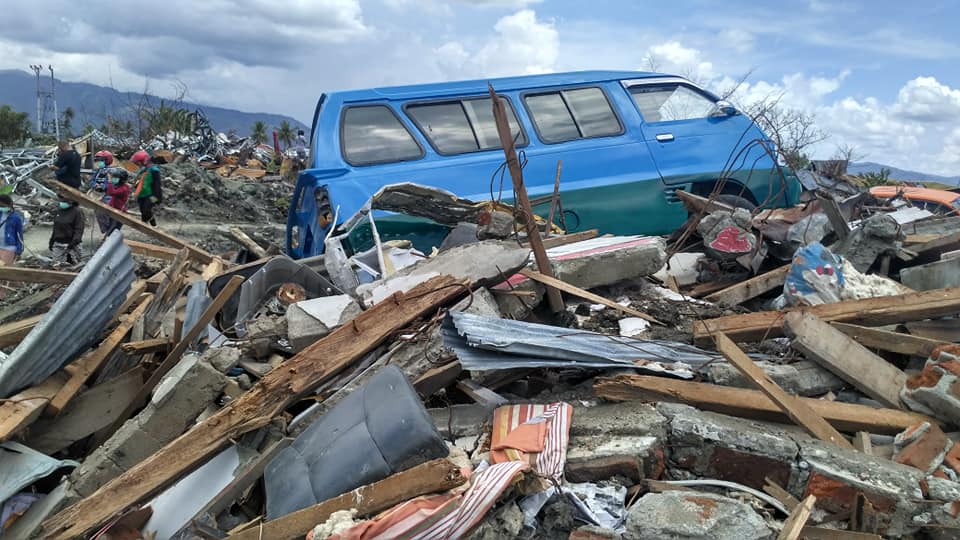 A van rests on rubble where homes stood before the tsunami struck