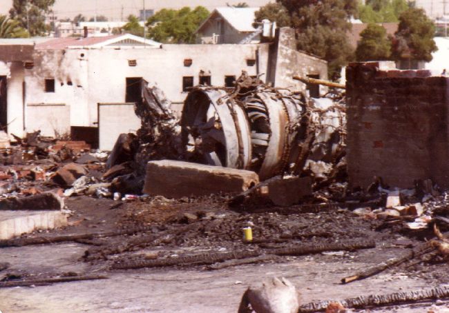 Wreckage of a jet engine lies among the ruins of a residential street
