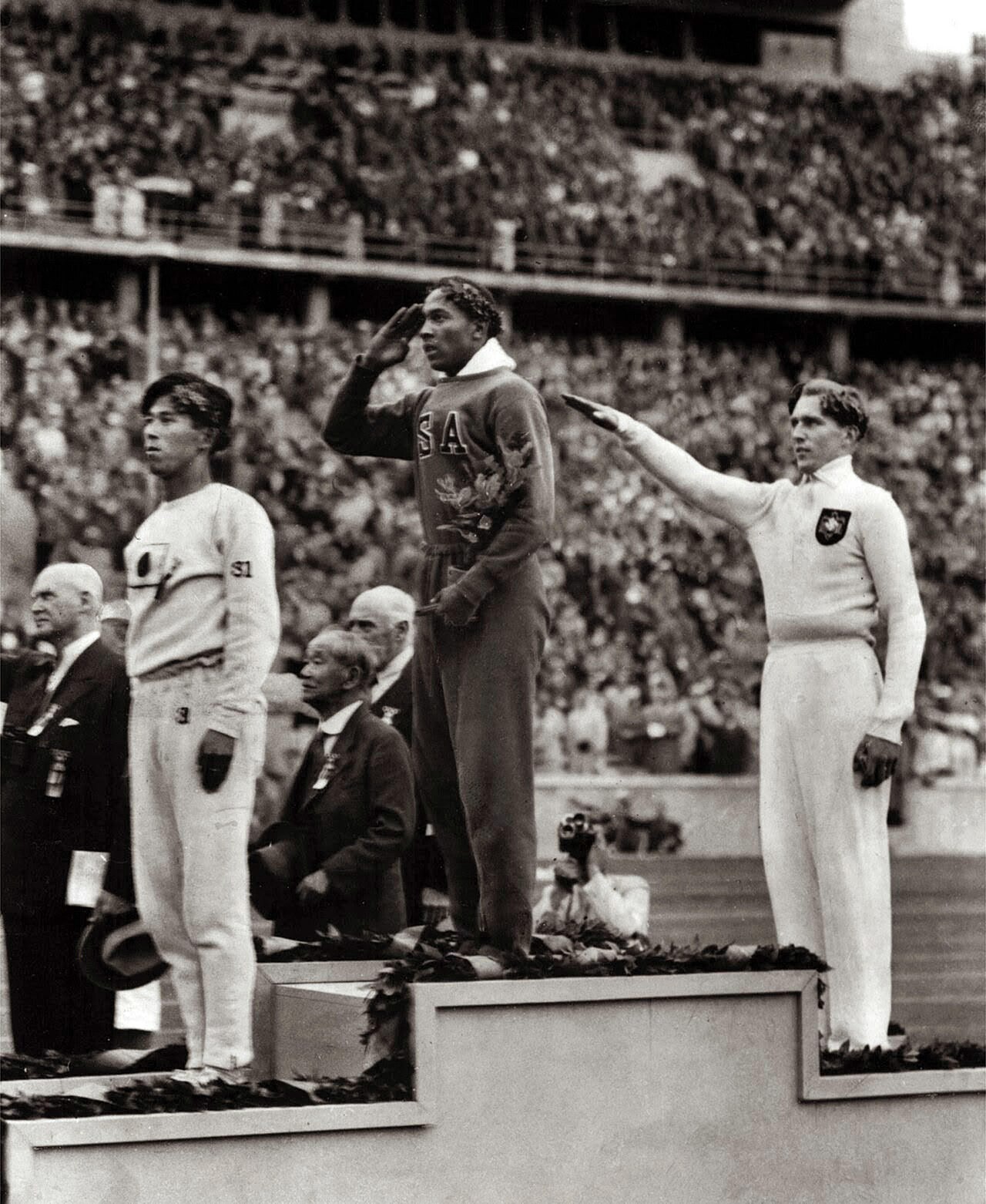 Jesse Owens salutes the flag after winning gold at the 1936 Berlin Olympic Games