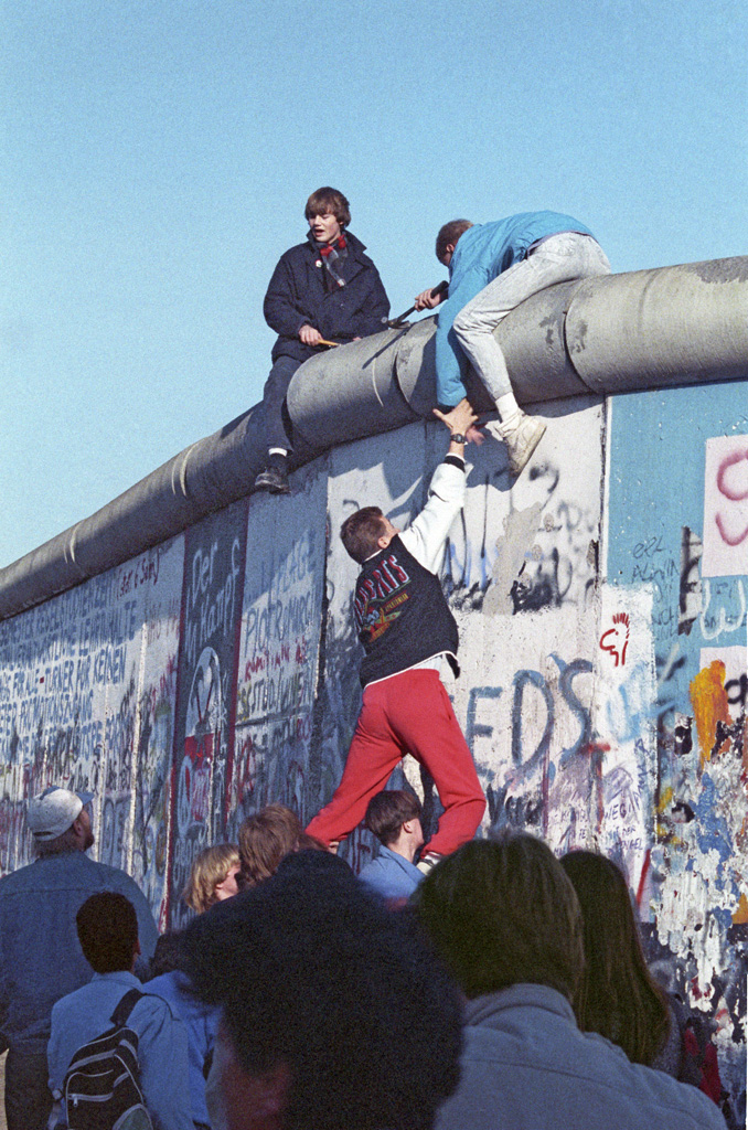 East Germans scale the Berlin Wall following the announcement of its immediate opening