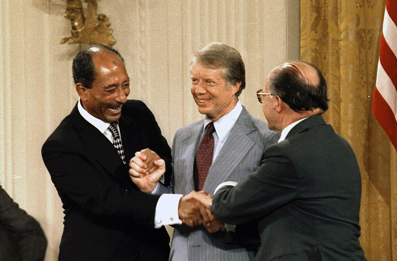 The Egyptian, American and Israeli leaders join hands after signing the accords