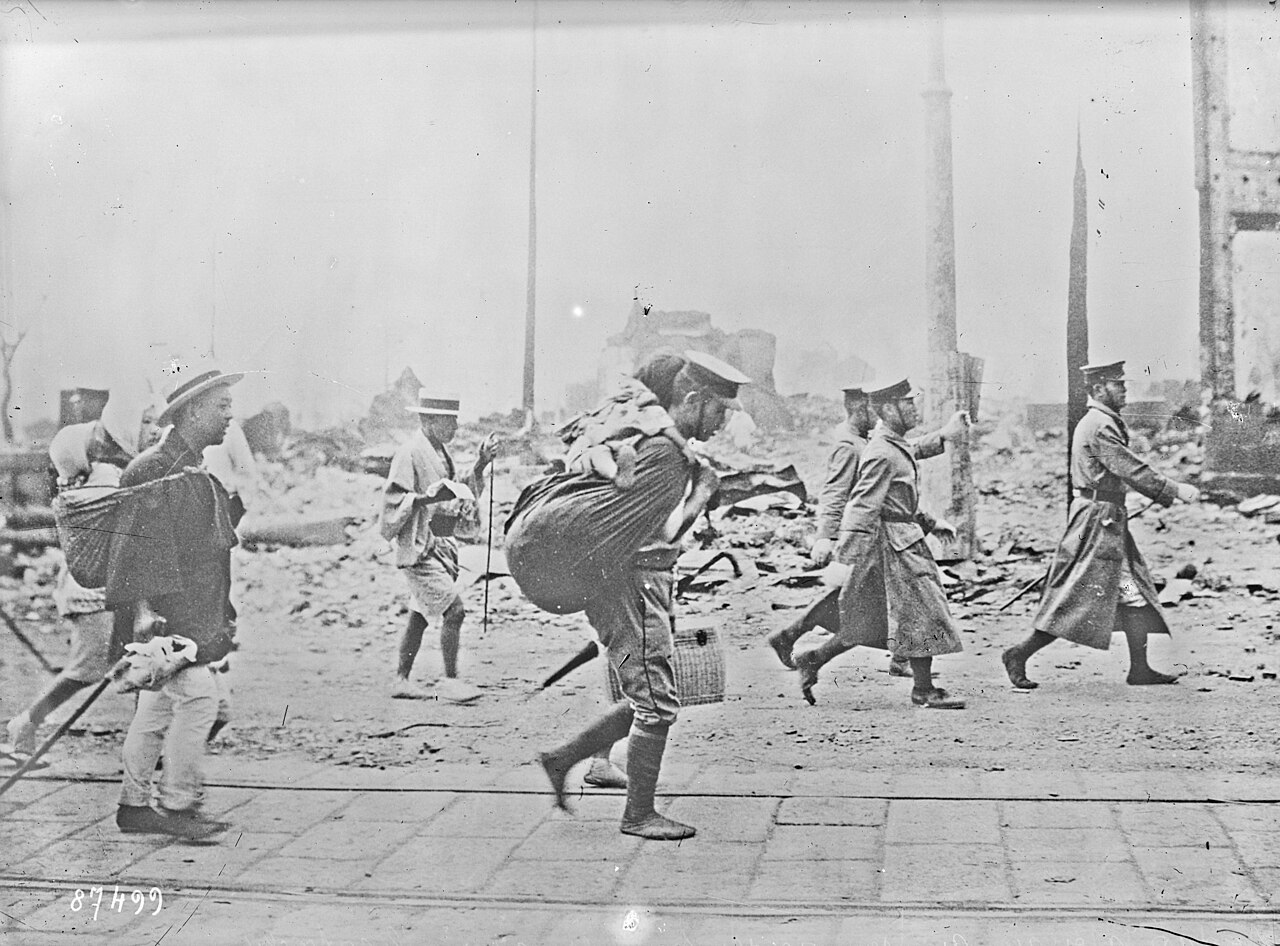 Survivors carry belongings through the rubble of Yokohama