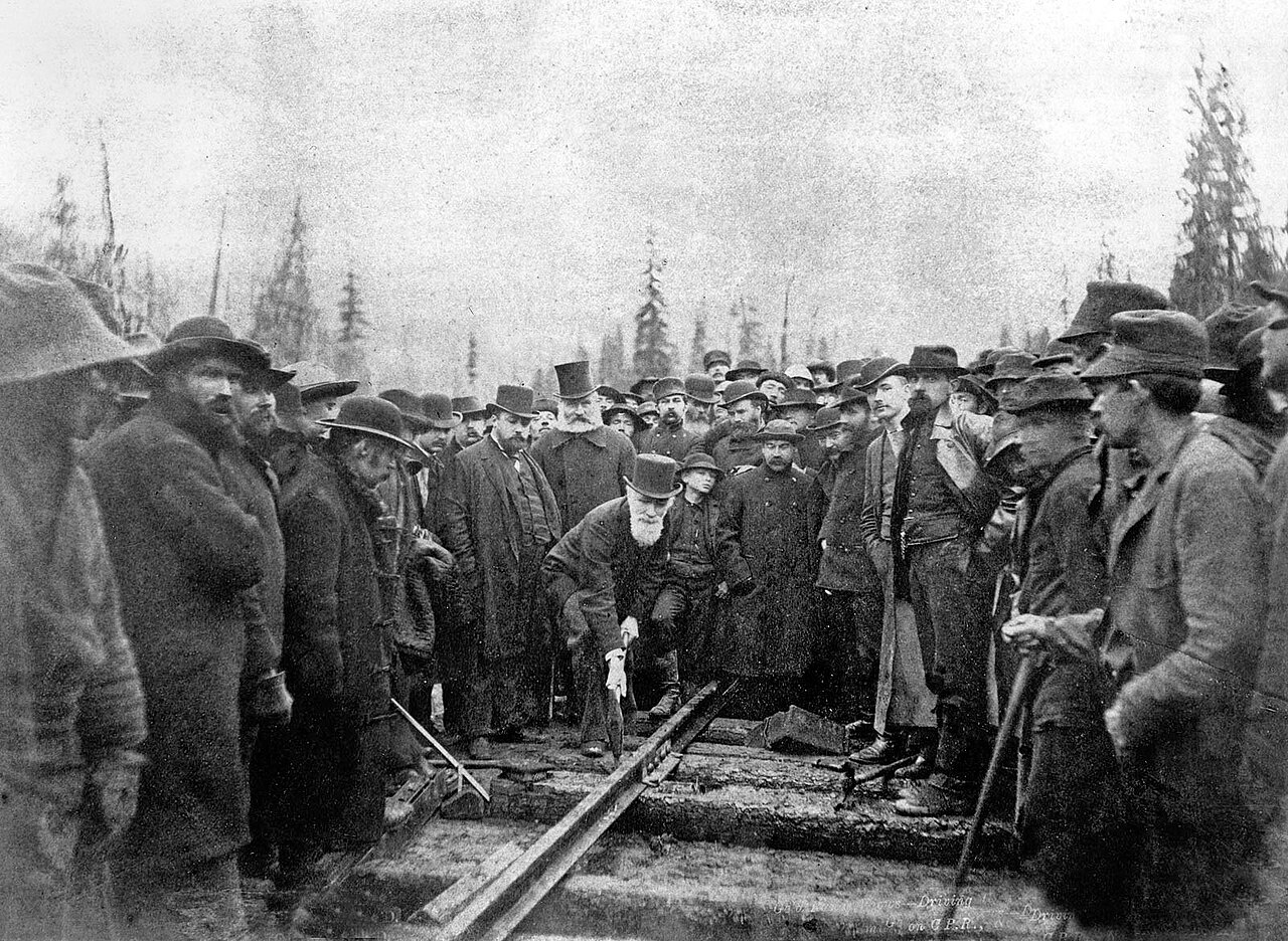Officials and workers gather as the last spike is driven at Craigellachie