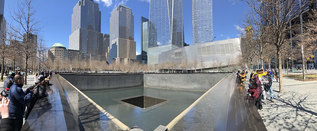 Visitors gather at the memorial pools during the dedication ceremony