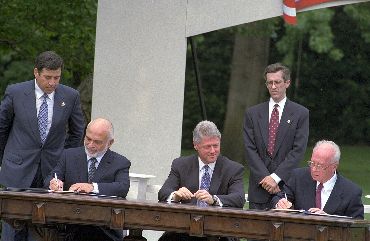 The Israeli and Jordanian leaders sign the peace treaty as the US president watches