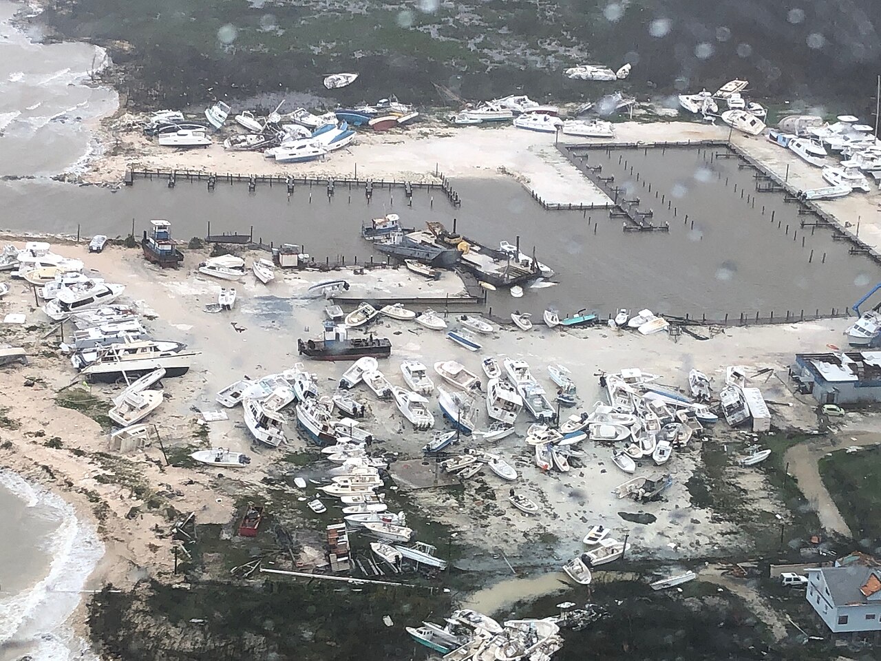 Boats lie scattered and wrecked in a marina on Grand Bahama