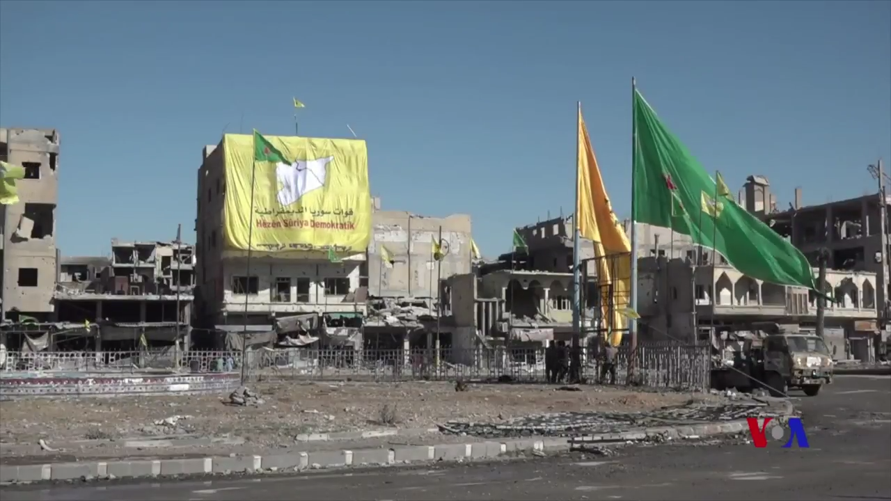 Syrian Democratic Forces raise their flags in Raqqa after capturing the Islamic State capital