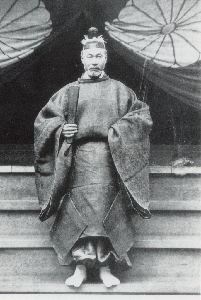 The Emperor stands in formal court attire at the palace