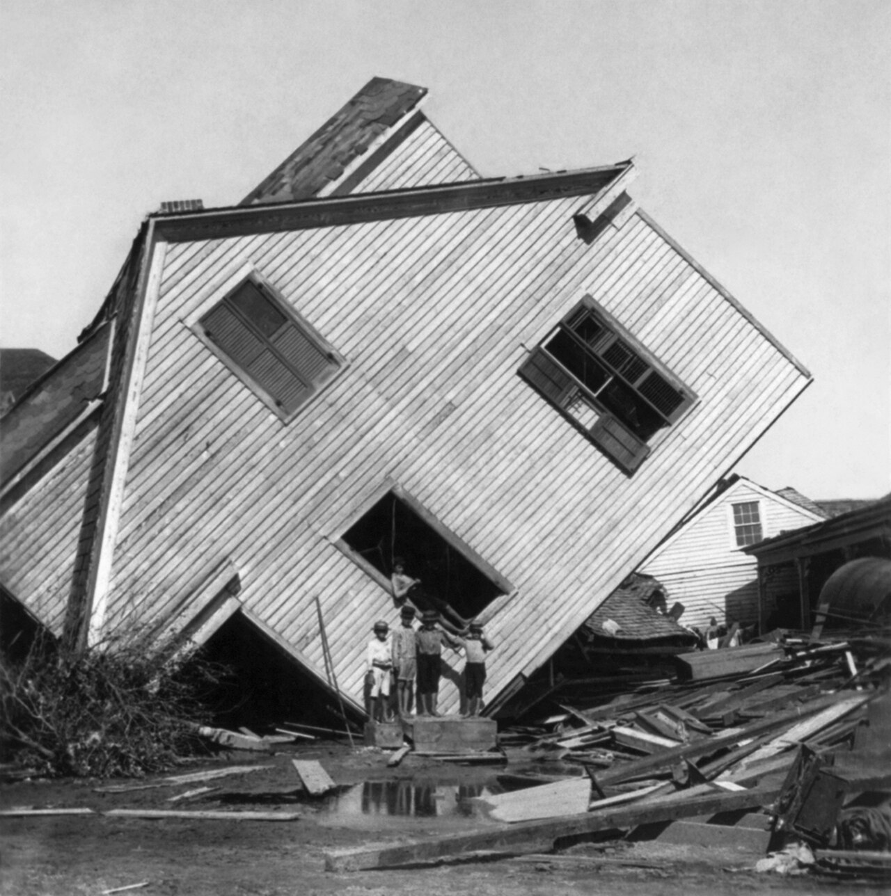 A house tilts crazily on Avenue N after the flood