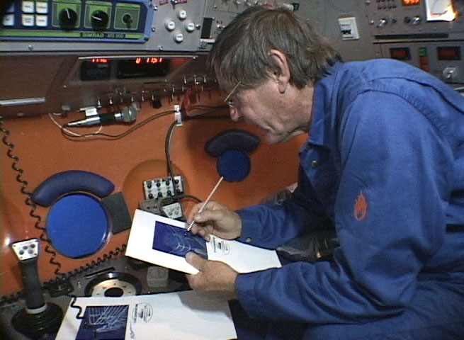 The expedition leader studies sonar images aboard the research vessel