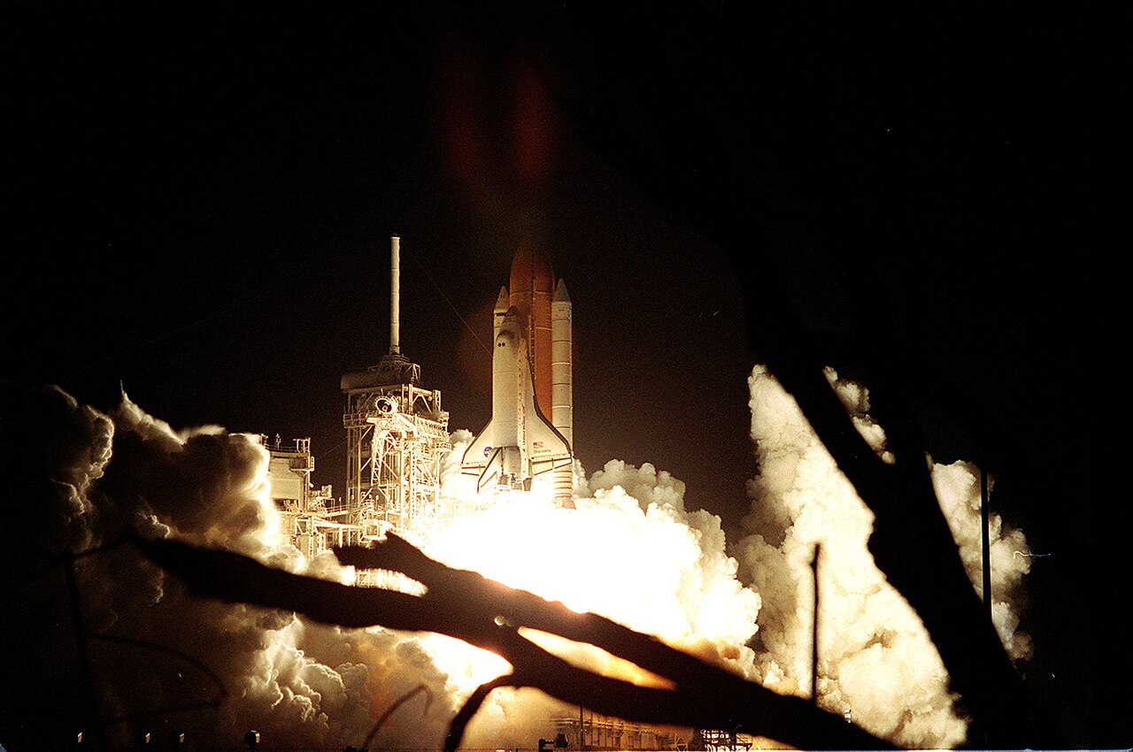 The shuttle clears the launch pad in a burst of flame