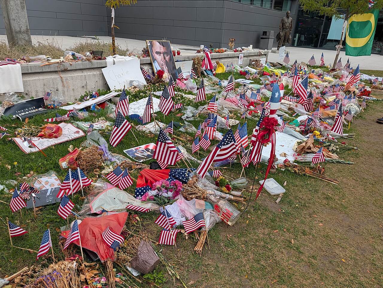 flowers and flags cover the ground where the activist fell