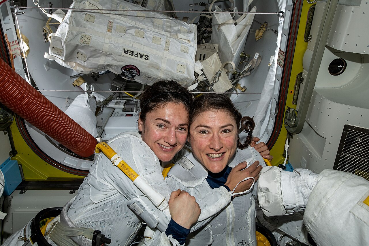 Astronauts Meir and Koch embrace in their spacesuits before the historic spacewalk