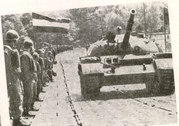 Warsaw Pact tank rolls past soldiers during the invasion