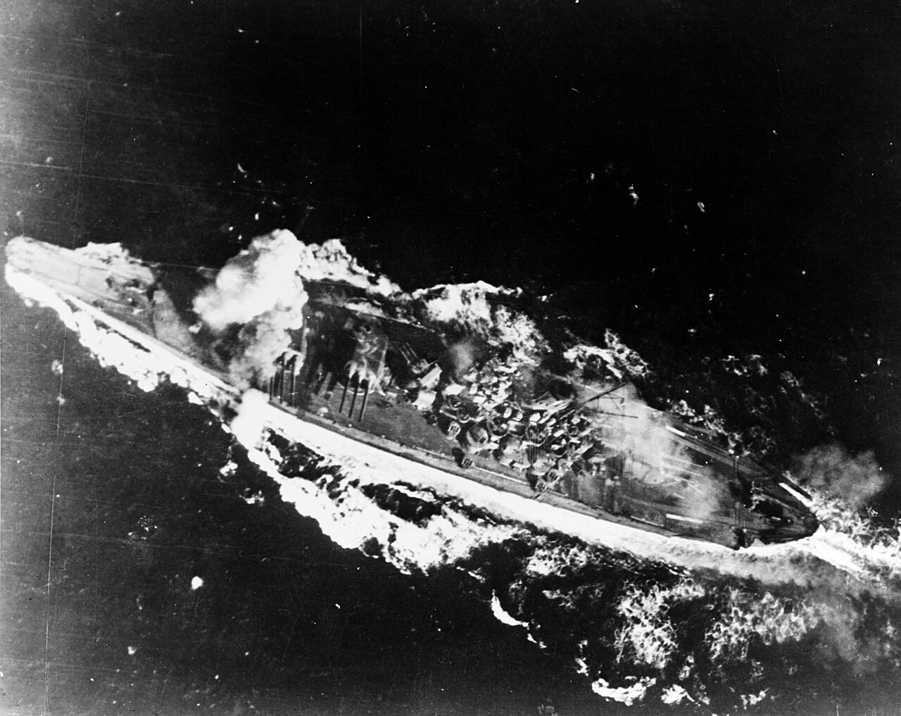 A Japanese battleship burns under attack from carrier planes