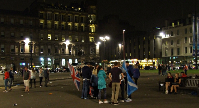 People gather in a city square with Union and Scottish flags after the vote