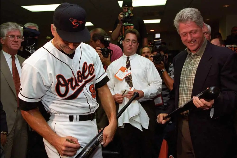 The shortstop signs a bat for the president after breaking the record