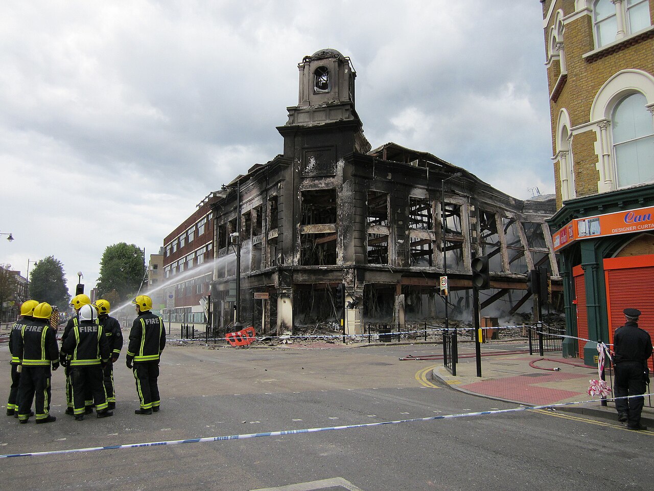 Firefighters dampen the ruins of the Reeves furniture store following the 2011 England riots