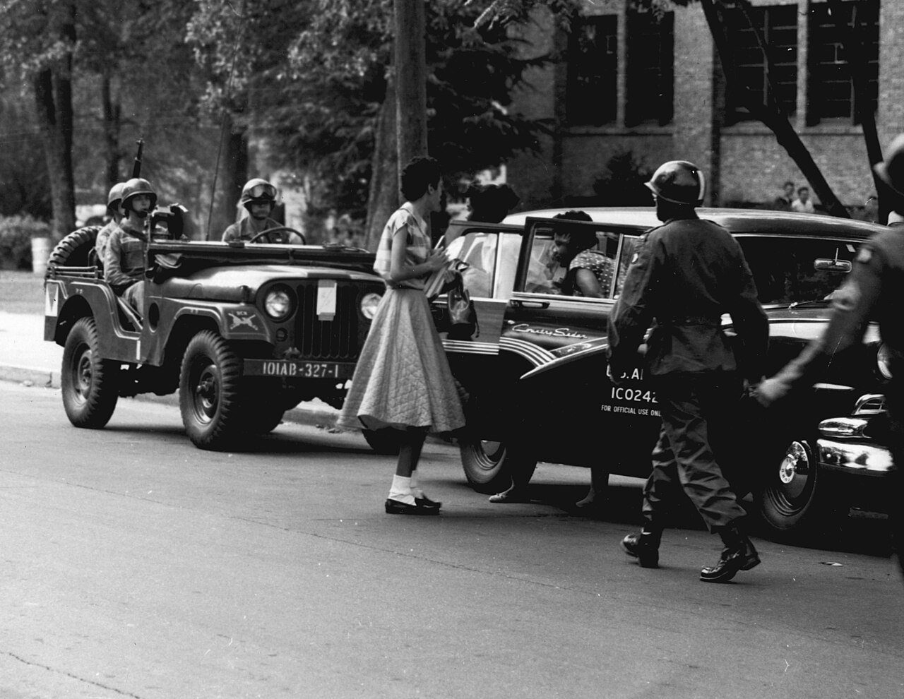 Federal troops in helmets and jeeps escort students to the high school